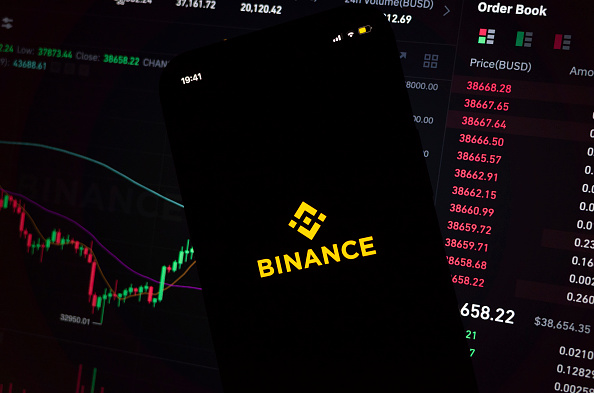 Binanceのアプリと取引画面を映したイメージ写真