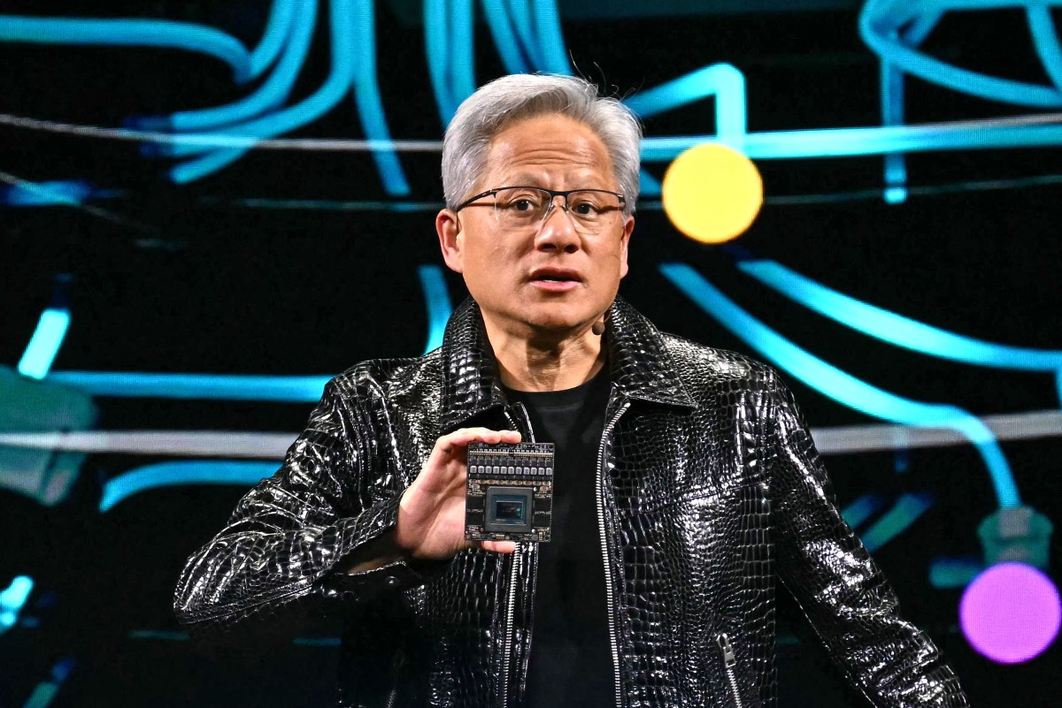 CES 2025でチップを掲げるNvidiaのJensen Huang(画像: TechCrunch / PATRICK T. FALLON / Getty Images)