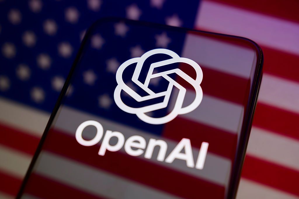 スマートフォンに表示されたOpenAIのロゴと米国旗